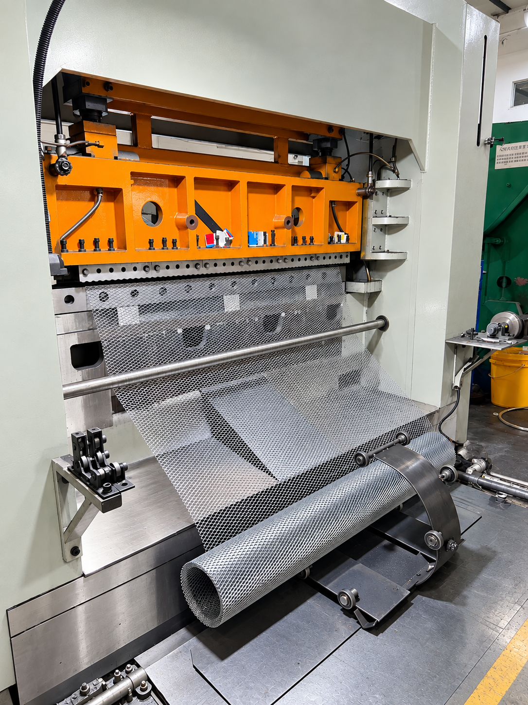 Industrial perforating press with perforated metal feeding into a coil