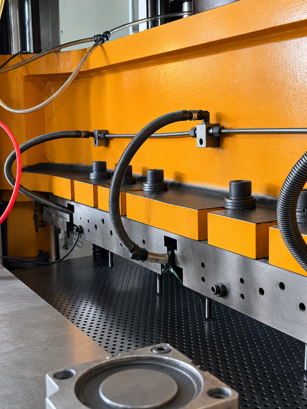 Close-up of perforating press tooling and round holes in metal sheet