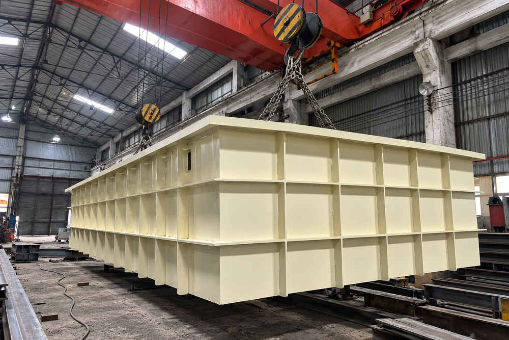Large painted steel fabrication with external stiffening ribs in a workshop